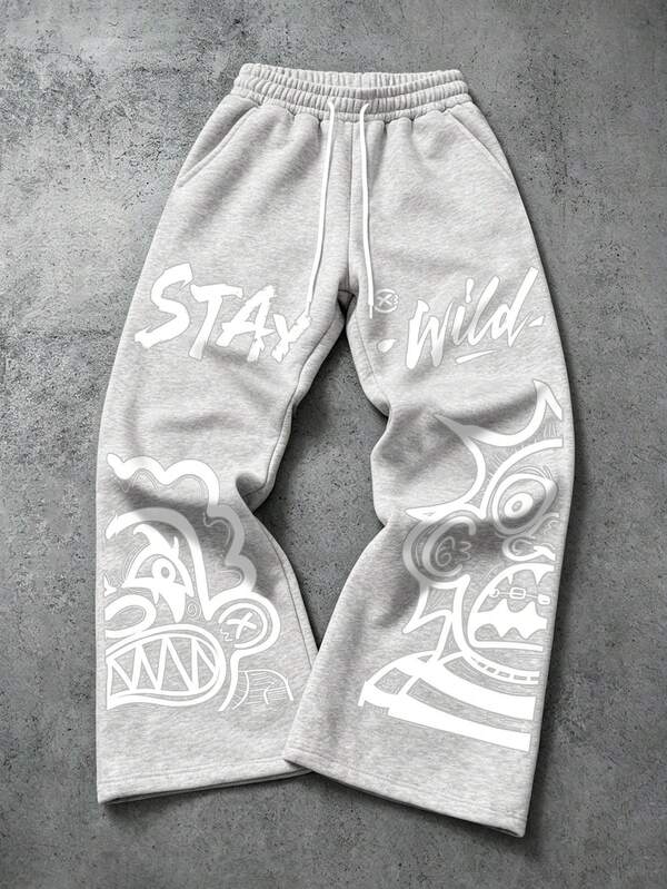 Manfinity EMRG Pantalones de chándal de pierna ancha gris carbón para hombre, pantalones largos casuales de estilo retro Y2K streetwear, estampado de cara abstracta de monstruo graffiti + letras Stay Wild, pantalones holgados de estilo gótico, adecuados para el festival de música Coachella, fiesta en club, reunión, vacaciones, atuendo para concierto