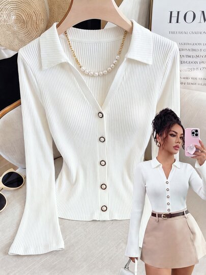 Qadelle Top acanalado blanco suave con cuello en V con cuello, botones de perla y mangas acampanadas para un aspecto refinado.