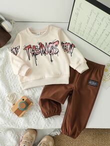 SHEIN طقم كنزة وبنطال رياضي للأطفال الصبيان من قطعتين، بلون بيج وبني مع طباعة حروف جرافيتي ورذاذ، أكمام طويلة وياقة دائرية، بقصة عادية، مناسب للخارج وللخريف - بني - مشاهدة 2