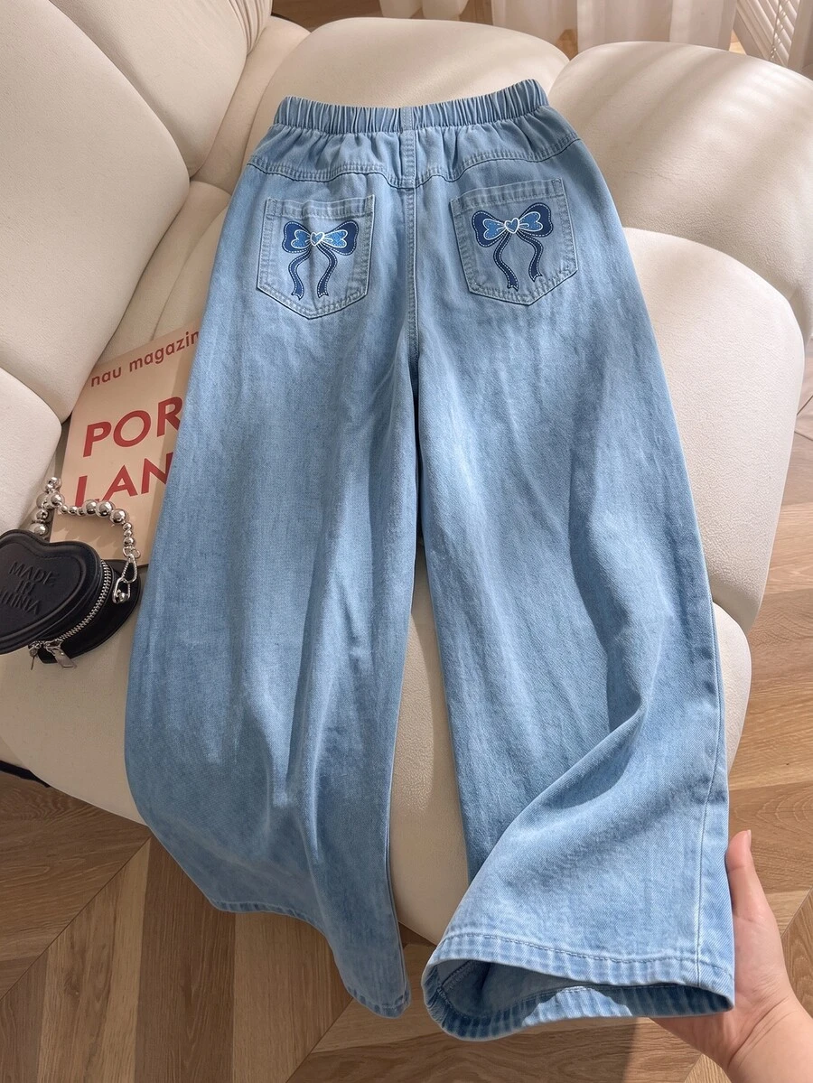 SHEIN Genkimix Kids 女童牛仔長褲,四季新款,美式休閒風,淺藍色牛仔,彈性腰頭配後口袋藍色蝴蝶結印花設計,結合牛仔酵素洗水工藝,直筒寬腿版型,柔軟舒適面料,易搭配,適合日常穿著、聚會、旅行等多種場合,四季新款女童牛仔長褲 - 淺色水洗藍 - 查看 1
