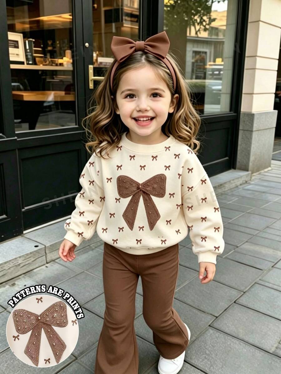 SHEIN Vintaside Kids Girls Toddler Spring/Autumn White All-Over Bow Print Crew Neck Sweatshirt Set, Pearl Rhinestone Large Bow Graphic Top + Pink High Elasticity Flared Long Pants 2 Pieces Set - Multicolor - View 1