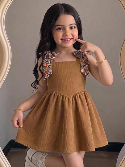 Young Girl Vintage Style Outfit & Caramel Corduroy Suspender Dress & Shoulder Strap Decorated With Floral Fabric Bowknot & Cinched Waist Flare A-Line Skirt Silhouette & Soft Skin-Friendly Fabric & Exquisite Craftsmanship & Suitable For Daily Outings, Dates, Outdoor Photography & Retro Chic Versatile For Various Spring And Autumn Occasions