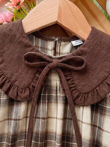 SHEIN 女童春秋復古格紋長袖洋裝，溫柔韓系森女風彼得潘領公主裙，深棕色彼得潘領配領口領結蝴蝶結裝飾，米色與咖啡色對比格紋布料，寬鬆A字大裙襬輪廓，復古藝術氣息，適合女童日常穿著 - 咖啡 - 查看 7