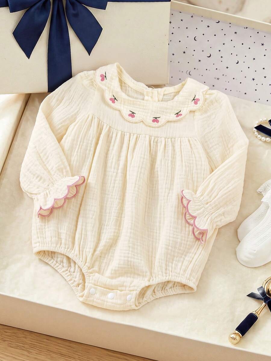 SHEIN رومبير فضفاض للبنات الرضع بتصميم لطيف وألوان متباينة، مطرز بنقشة الكرز، بياقة بيتر بان، ناعم ومكشكش، بأكمام طويلة وحافة مكشكشة، مناسب للشتاء - لون مشمشي - مشاهدة 1