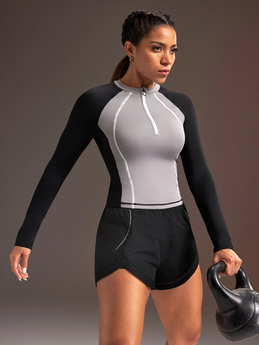 Powerista بلوزة رياضية نسائية بأكمام طويلة بتصميم راجلان وألوان متباينة مع سحاب وفتحة نصفية - الأسود - مشاهدة 1