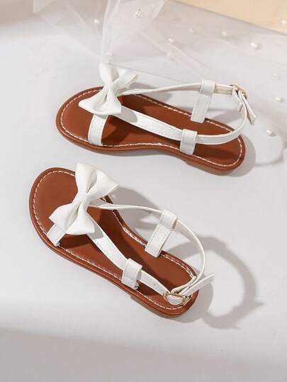 一双白色女童凉鞋新款蝴蝶结公主鞋松紧带设计软底休闲女童沙滩鞋夏季。