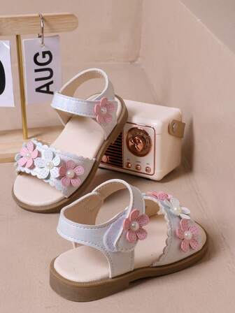 女婴凉鞋浅色装饰，粉色和白色花朵图案，带珍珠点缀，扇形边缘，钩环带方便穿着，适合儿童夏季日常外出和活动