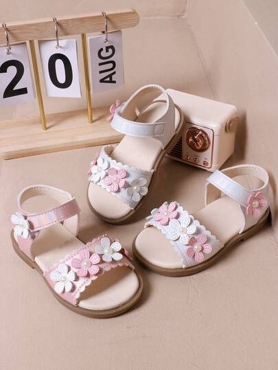 女宝宝凉鞋，浅色调搭配粉白花朵装饰，珍珠点缀中心，波浪边设计，甜美精致，魔术贴带方便佩戴，适合儿童夏季日常休闲出游