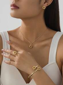 1 套女士珠宝包括 1 条带经典金属扭曲几何吊坠的项链、1 对耳环、1 枚戒指、1 条手链