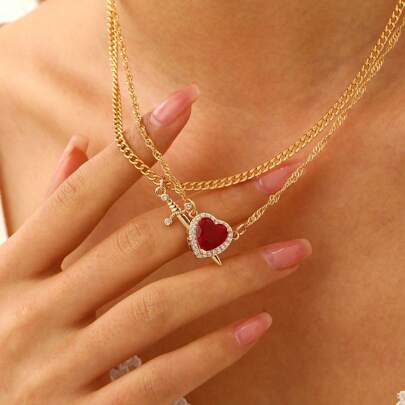Un collar con un corazón con zirconia roja atravesado por una flecha, accesorio versátil y exquisito adecuado para uso diario, vacaciones y como regalo