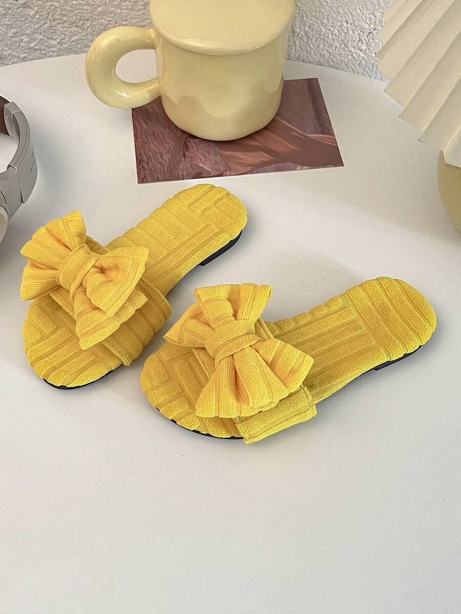 A Pair Of Summer Hot Kids' Non-Slip Slippers. The Upper Is Made Of Yellow Towel Material, With Checked Texture, And The Front Is Decorated With A Large Bow, Which Is Sweet And Lovely. Suitable For 3-12 Year Old Girls To Wear At Home, Comfortable And Can Add Children's Fun; Can Also Be Worn In Warmer Weather, Is Both Practical And Beautiful Fashion Items. - Yellow - View 1