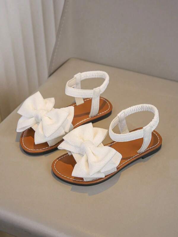 A Pair Of White Girls' Sandals New Bow Princess Shoes Elastic Band Design Soft-Soled Casual Girls' Beach Shoes In Summer.