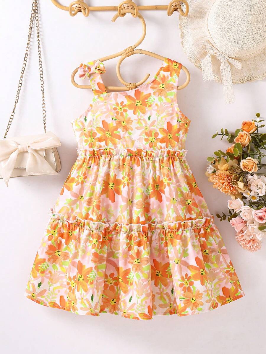 年轻女孩轻薄雪纺吊带连衣裙，配黄色花卉印花和蝴蝶结肩带，休闲海滩度假装，夏季