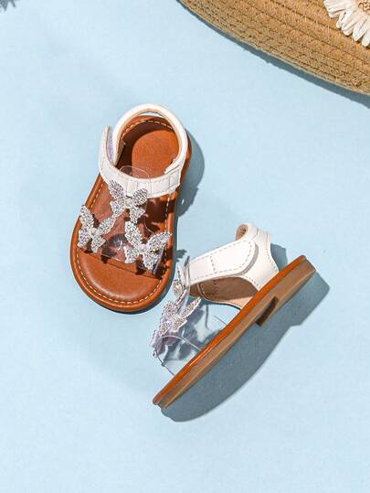 带透明蝴蝶装饰和钩环扣的可爱白色婴儿凉鞋