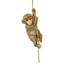 Statue décorative en résine d'un bébé chimpanzé grimpant sur un arbre dans un décor de jardin animal