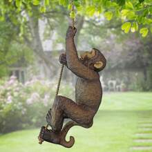 Statue décorative en résine d'un bébé chimpanzé grimpant sur un arbre dans un décor de jardin animal