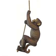 Statue décorative en résine d'un bébé chimpanzé grimpant sur un arbre dans un décor de jardin animal