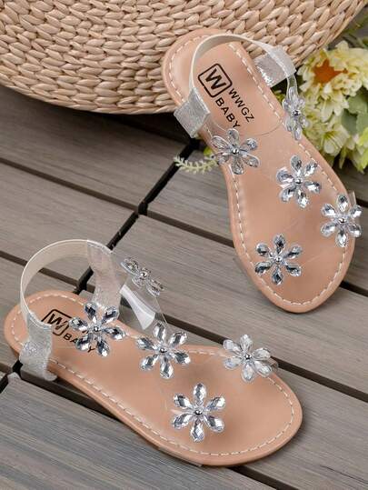 A Pair Of Summer Bestselling Children's Non-Slip Sandals. The Upper Body Is Light Brown, With Transparent PVC Tape Design, Decorated With Multiple Silver Rhinestone Flowers, Delicate Shine.