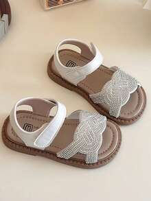 一双畅销款白色儿童凉鞋，鞋身白色，鞋头有水钻编织图案，白色踝带，棕色鞋底。款式华丽亮丽，属于夏季时尚款，适合儿童日常、度假等场景，适合3-12岁儿童 - 米色 - 查看 4