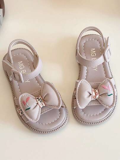 一双夏季畅销女童凉鞋，浅灰色调，柔软甜美。鞋面饰有精致的蝴蝶结和精美刺绣，可爱又时尚。采用耐磨材质，舒适柔软。交叉绑带搭配魔术贴设计，方便穿脱，适合3-12岁女孩室内外穿着。编织松紧带增添时尚感，适合3-12岁儿童。