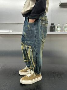 年轻男孩时尚宽松破洞拼布和刮擦印花牛仔裤，春季