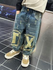 年轻男孩时尚宽松破洞拼布和刮擦印花牛仔裤，春季