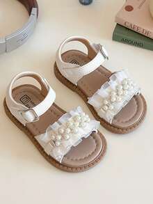 这款广受欢迎的白色儿童凉鞋采用白色鞋带和金属扣设计，鞋面为褶皱白色，并饰有仿珍珠。甜美优雅的风格是夏季时尚之选，适合儿童日常穿着和度假，适合3-12岁的儿童。 - 米色 - 查看 3
