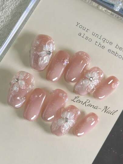 10片装DIY人造指甲套装，3D手工制作，冰晶透明百合花造型，粉色渐变表面，饰以不对称水滴图案。佩戴后，令双手更显白皙、优雅，简约迷人。套装包含1片人造指甲、1瓶凝胶和1把指甲锉。适用于日常生活、婚礼、商务场合、派对等各种场合。按压式指甲 美甲用品 手工按压式指甲