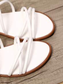 زوج من الصنادل المسطحة الأنيقة والكاجوال من الجلد اصطناعي باللون الواحد ذات أشرطة متقاطعة مناسبة للعطلات والشاطئ والسفر والحفلات الخارجية