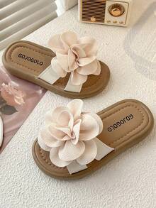 一双夏季热销儿童防滑拖鞋。鞋面饰有大朵浅米色花朵，造型逼真，立体感十足。鞋底为浅棕色，鞋垫印有“GOJO”字样。整体风格甜美可爱，适合3-12岁女童居家、散步等休闲场合穿着，更能增添童真童趣。