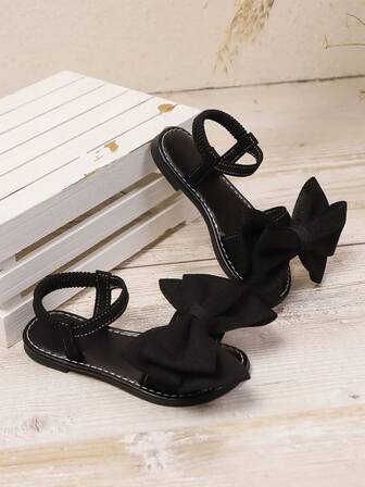 一双白色女童凉鞋夏季新款蝴蝶结公主鞋松紧带设计软底休闲女童沙滩鞋。