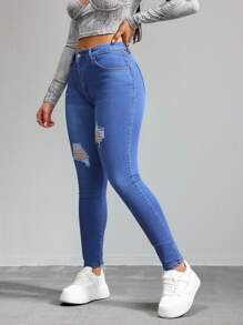 Jeans ajustados de cintura alta en azul con desgarros, tela suave y elástica, ideal para estilos casuales y versátiles