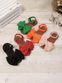 一双白色女童凉鞋夏季新款蝴蝶结公主鞋松紧带设计软底休闲女童沙滩鞋。