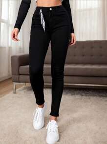 Mujer skinny jeans negros con pañoleta decorativa
