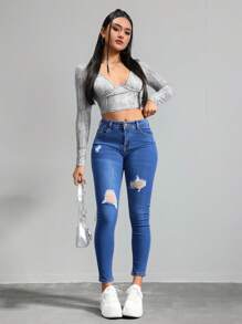 Jeans ajustados de cintura alta en azul con desgarros, tela suave y elástica, ideal para estilos casuales y versátiles