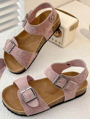 A Pair Of Summer Children's Non-Slip Sandals. The Vamp Is Made Of Pink Suede Material With Two Straps With Metal Buckle, Which Can Be Adjusted For Tightness. The Sole Is Partly Made Of Cork With A Black Non-Slip Outsole. The Overall Style Is Sweet And Casual, Suitable For 3-12 Years Old Girls In The Summer Daily Travel, Walking Play And Other Occasions To Wear, Can Show A Gentle And Lovely Elegant.