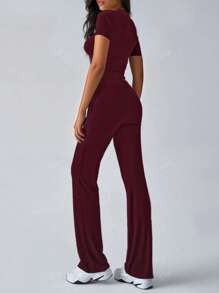 Tuta sportiva da donna alla moda per la primavera, con top a maniche corte che scopre la pancia e pantaloni a zampa aderenti con lacci