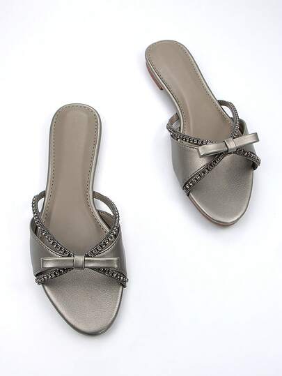 Dép lê nữ thanh lịch, quai mảnh khoét rỗng, đính đá và nơ, chất liệu PU màu xám, kiểu dáng thời trang, thoải mái, mũi tròn, thích hợp cho cả đi chơi hàng ngày và dự tiệc, phối hợp với trang phục mùa xuân hè.