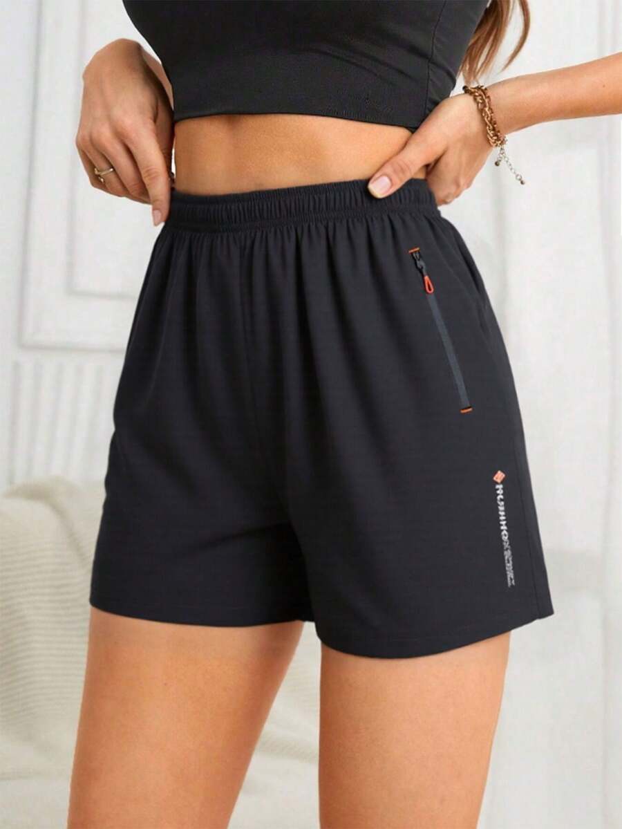 Shorts de corrida femininos pretos de secagem rápida com bolso lateral com zíper - cintura elástica com cordão, shorts esportivos com design de tipografia contrastante para academia, exercícios ao ar livre