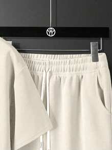 Conjunto de camiseta casual de manga corta de cuello redondo y unicolor, y shorts con estampado de letras y cordón en la cintura para hombres en verano