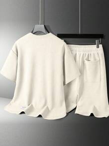 Conjunto de camiseta casual de manga corta de cuello redondo y unicolor, y shorts con estampado de letras y cordón en la cintura para hombres en verano