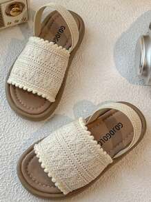 A Pair Of Children's Sandals. The Upper Is Made Of Cream-Colored Crochet Material, And The Edge Is Decorated With Pompoms. The Design Is Exquisite And Cute, And The Hook And Loop Belt Of The Same Color Is Matched. The Overall Style Is Sweet And Casual, Suitable For 3-12 Year Old Girls In The Summer Daily Travel, Walking And Other Occasions To Wear, Can Show The Pure And Lovely Elegant.