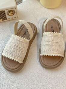 A Pair Of Children's Sandals. The Upper Is Made Of Cream-Colored Crochet Material, And The Edge Is Decorated With Pompoms. The Design Is Exquisite And Cute, And The Hook And Loop Belt Of The Same Color Is Matched. The Overall Style Is Sweet And Casual, Suitable For 3-12 Year Old Girls In The Summer Daily Travel, Walking And Other Occasions To Wear, Can Show The Pure And Lovely Elegant.