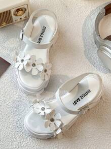 Un par de sandalias de plataforma blancas de moda de verano para niñas de 3 a 12 años, con elementos decorativos florales para un toque romántico. La parte superior es suave y cómoda, con diseño de gancho y lazo para un ajuste fácil, ya sea para juegos en interiores o paseos al aire libre, puede proporcionar un acompañamiento cómodo para los niños.