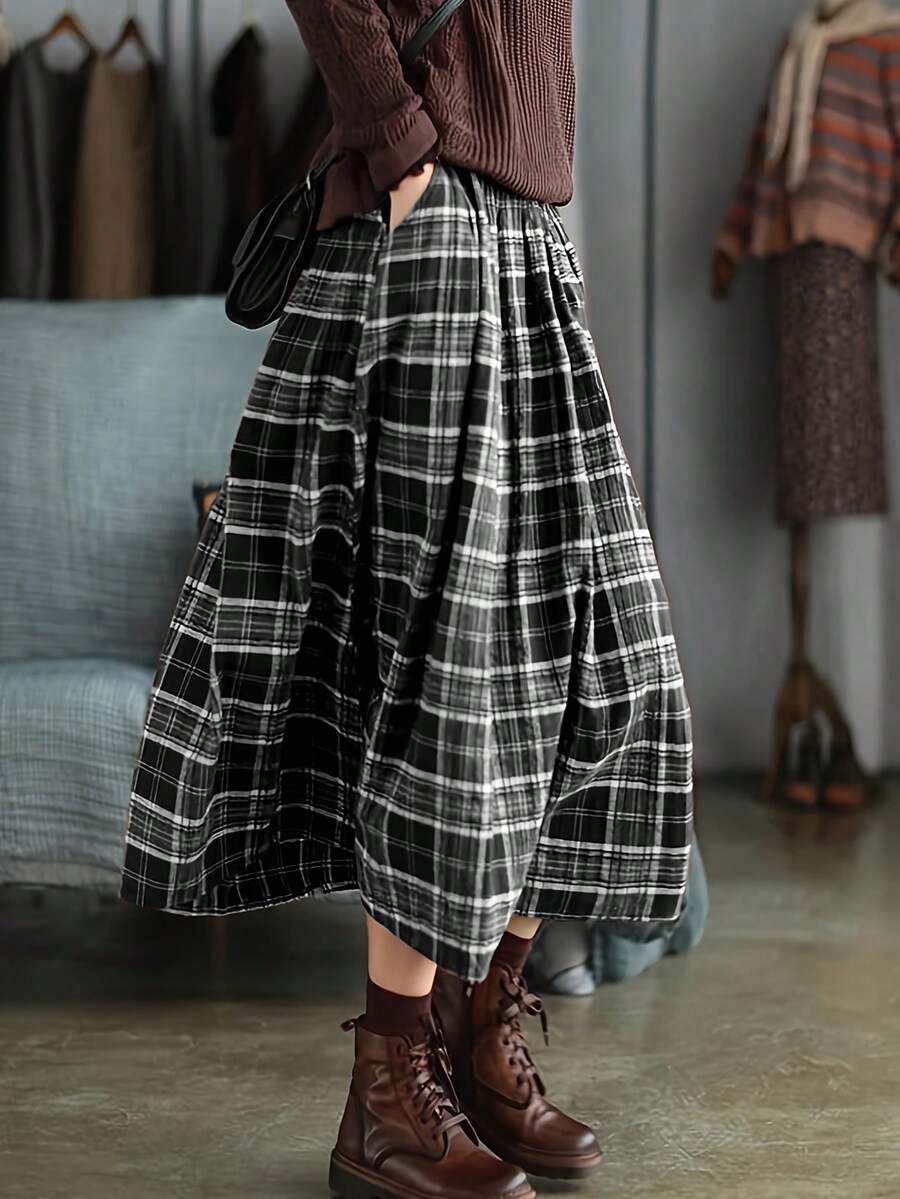 Chân váy kẻ caro phong cách retro mùa xuân hè mới, màu nâu, cạp cao, dáng xòe, dài ngang gối, kiểu dáng rừng cây đa năng, ôm sát và che phủ hông. Thiết kế kẻ caro retro, thoáng khí và thân thiện với da mà vẫn giữ được phom dáng. Thích hợp cho công sở và các dịp hàng ngày, đây là một món đồ đa năng giúp nâng tầm tủ đồ mùa xuân hè của bạn. Màu đen