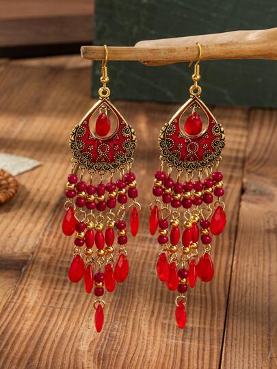 A Pair Of Bohemian-Style Retro Earrings With Carved Patterns And Oil-Drop Details, Teardrop Tassels Made Of Seed Beads. Suitable For Ladies To Wear During Festival Celebrations.