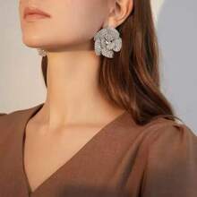 Une paire de boucles d'oreilles élégantes ornées de rhinestones en forme de pétales de rose pour femmes, avec des ornements de rhinestones luxueux.