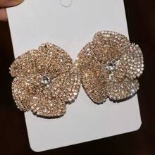 Une paire de boucles d'oreilles élégantes ornées de rhinestones en forme de pétales de rose pour femmes, avec des ornements de rhinestones luxueux.
