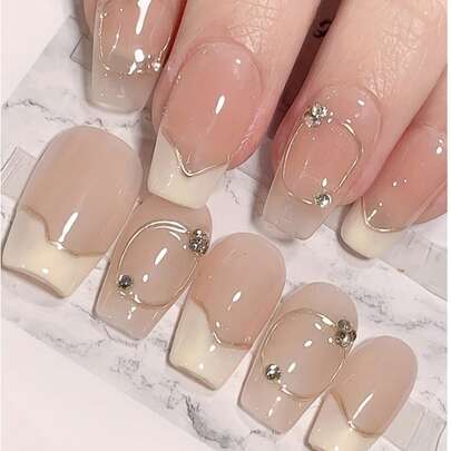 10片手工制作的法式美甲贴片，不对称白色底金色线条，点缀几颗小水晶，短款按压式美甲贴片，可重复使用，可卸除，附赠工具包，适合日常佩戴和节日送礼，送给爱美的女孩，圣诞礼物，美甲用品