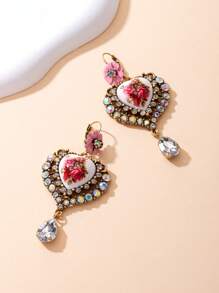 Il s'agit d'une paire de boucles d'oreilles bien conçues. Le style appartient à l'esthétique vintage et romantique, en mélangeant divers éléments : - Conception principale : Pièces en céramique en forme de cœur avec des motifs floraux rouges, ce qui donne une ambiance artistique et romantique. - Éléments décoratifs : les bords des formes de cœur sont garnis de nombreux strass scintillants, ajoutant une touche de luxe.